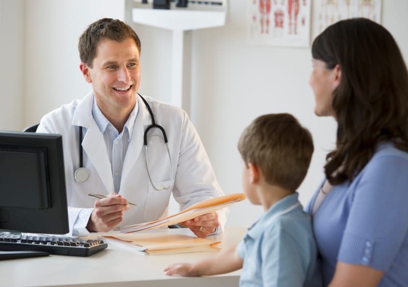 Doctor consulting a parent at the medical clinic.