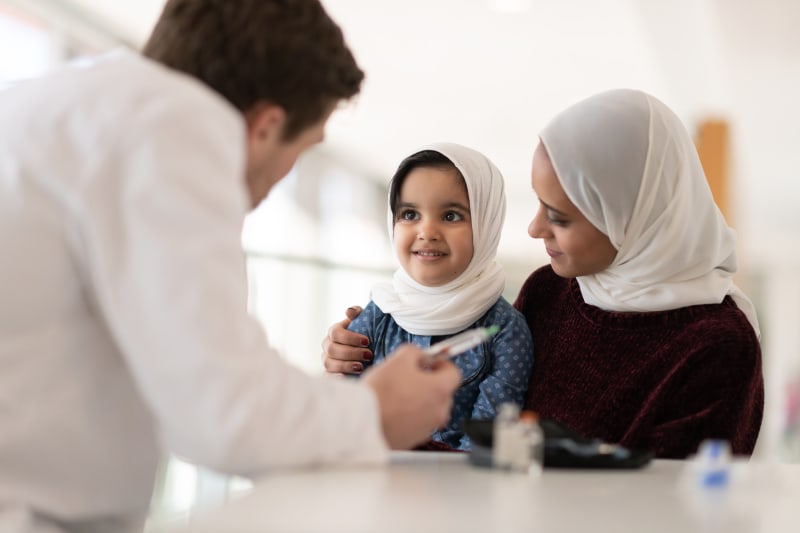 Mother and Daughter with Doctor checking glucose levels.