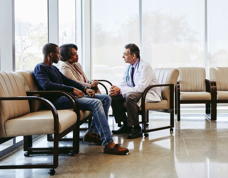 Doctor in hospital speaking with parents.