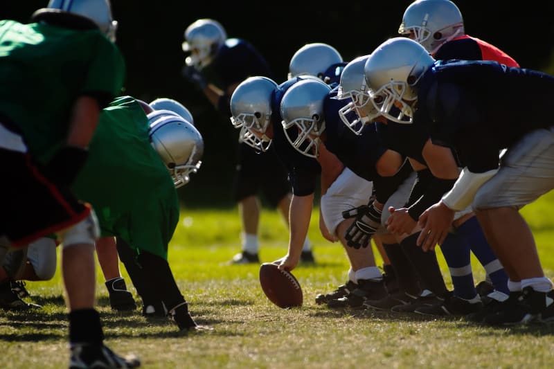 Middle school football players lined up on the field before the snap.