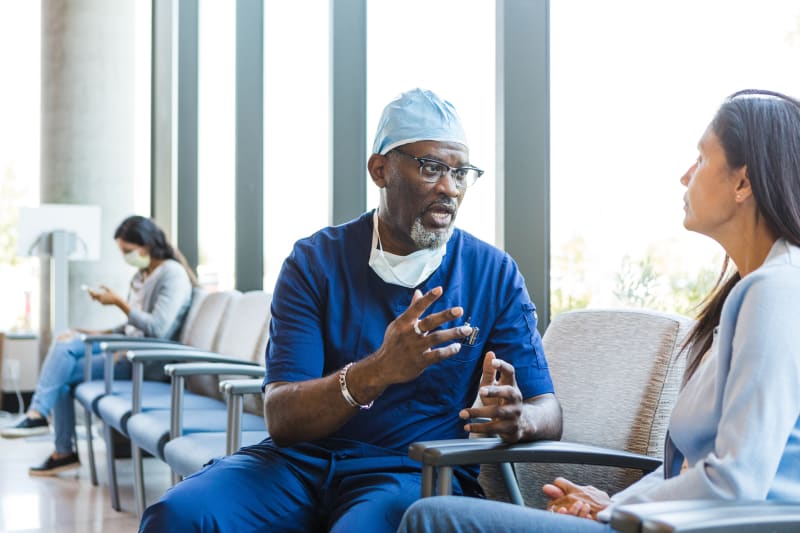 Surgeon talking to parent in hospital waiting room.