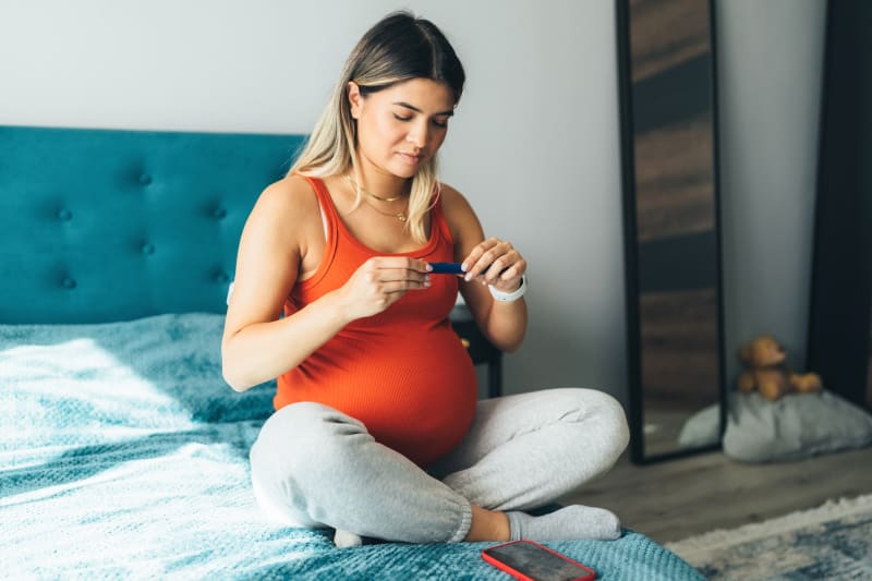 Pregnant woman checking blood glucose levels. 
