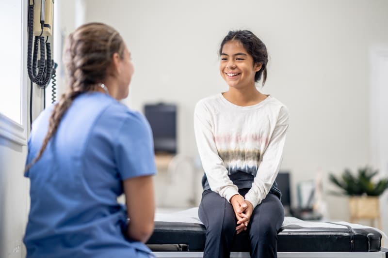 Female teenager talking to her doctor.
