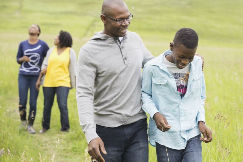 Father and Son walking in a park with Family.
