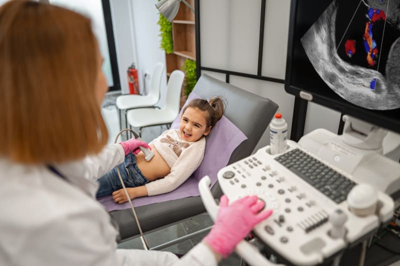 Young girl at doctor's office having abdominal ultrasound. 