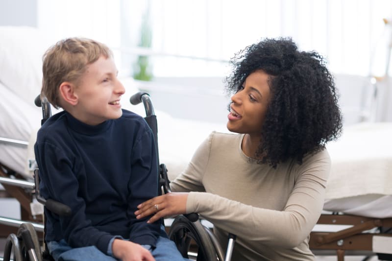 Child in wheelchair with Occupational Therapist.