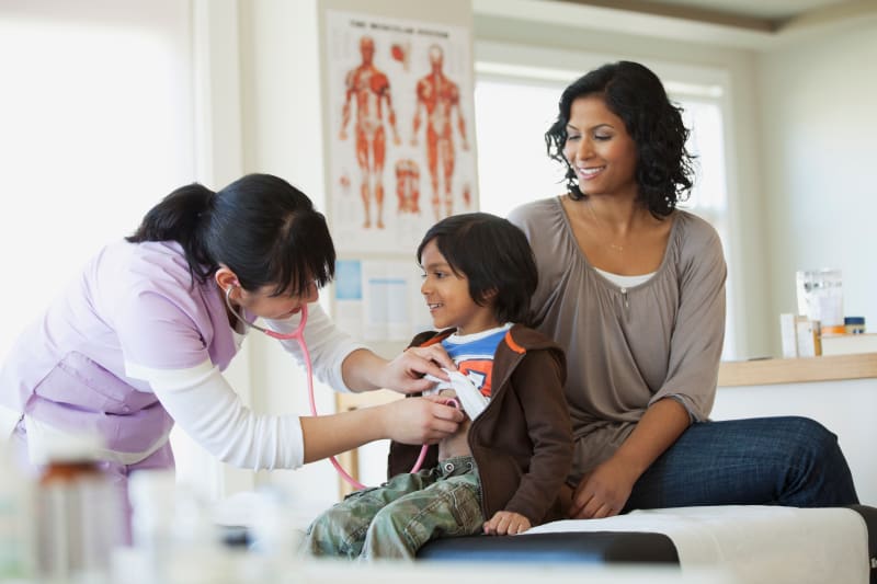 Doctor listening to Child's heart with stethoscope at check-up.