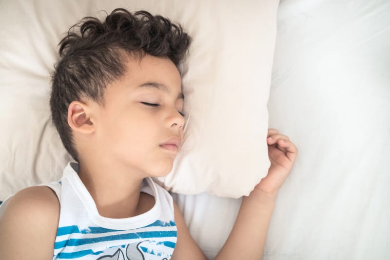 Child sleeping soundly on pillow.
