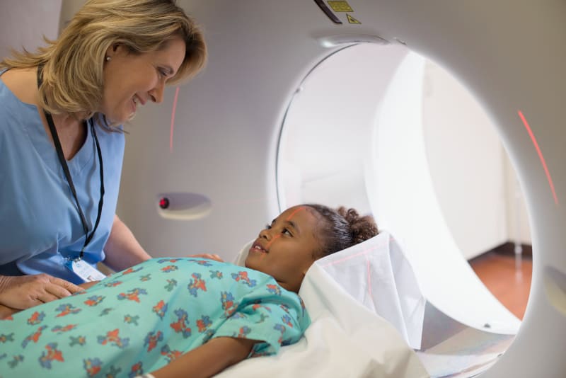 Young Girl laying on MRI table preparing for scan. 