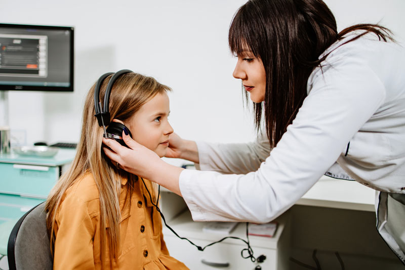 An beautiful teenage girl getting an auditory test at a hearing clinic. 