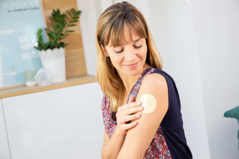 Woman putting on nicotine patch