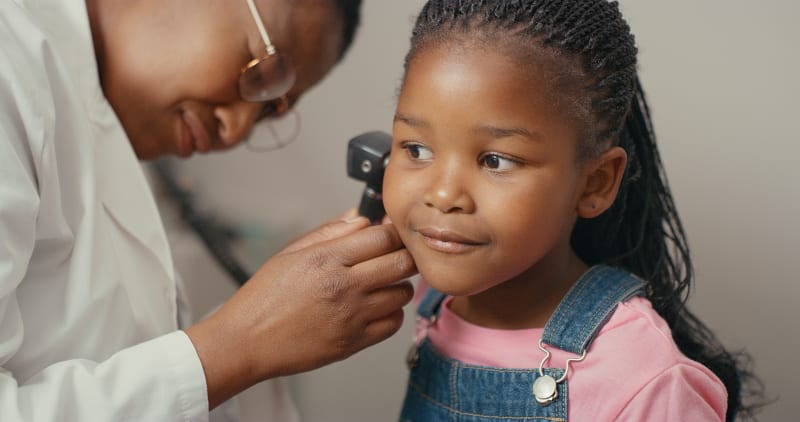 Child getting their ear checked by doctor 