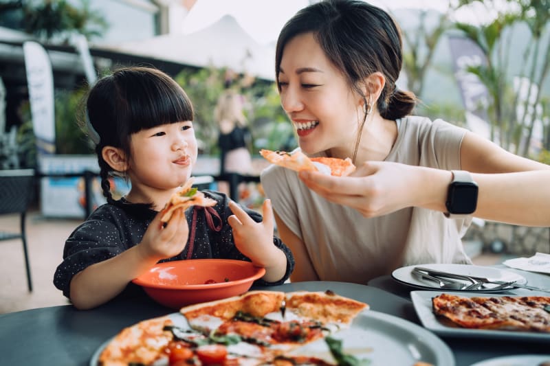Mother and Daughter eating pizza together.