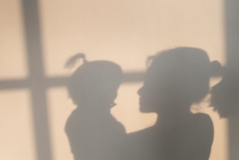 Shadow silhouette of mother holding her child. 