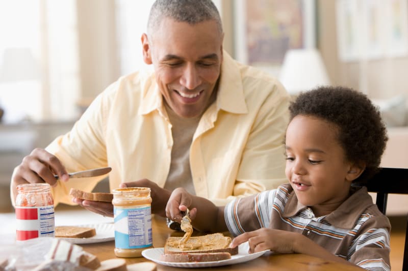Young Child eating lunch with Dad.