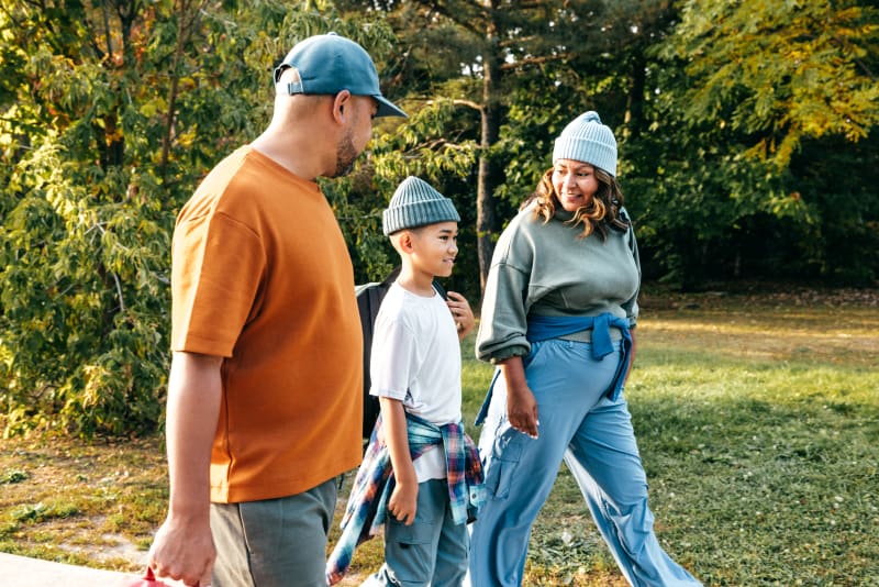 Parents walking with young son in the park. 