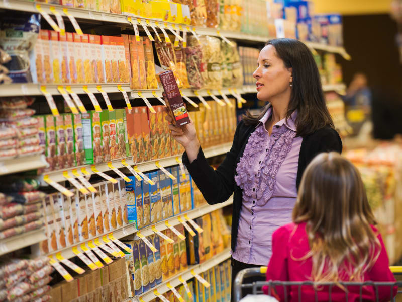 Mom shopping for healthy options at supermarket with Daughter.