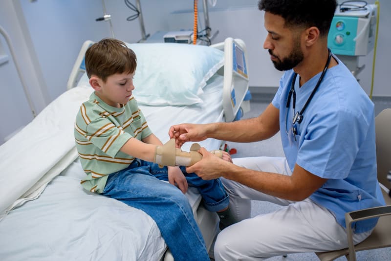 A nurse putting a splint on child's wrist.