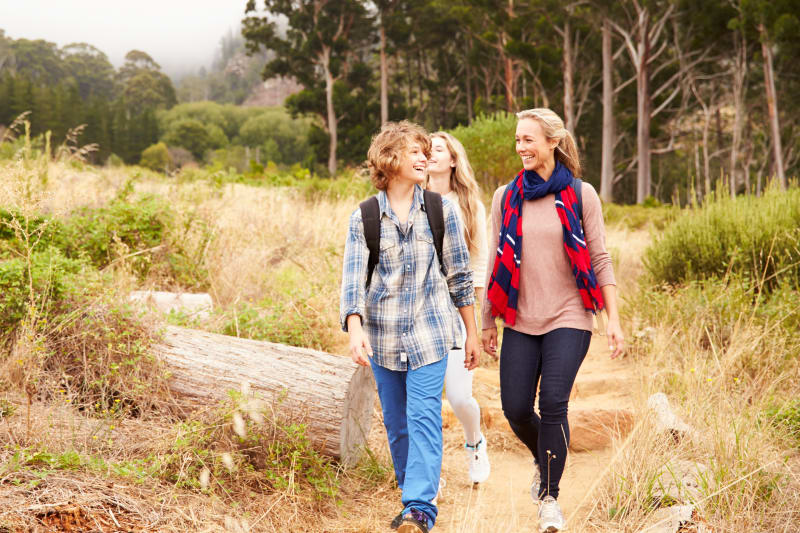 Mom hiking in nature with her two teenage children.