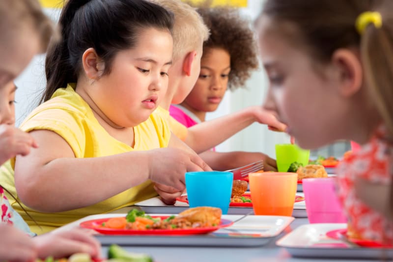 Child at school eating lunch with friends.