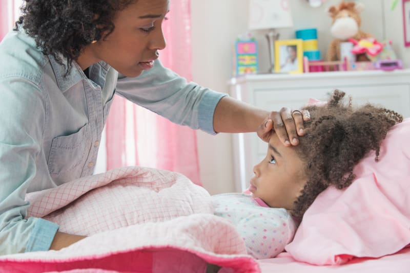 Mother checking child's head for fever.