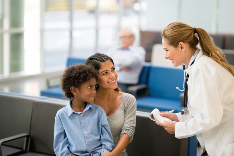 Child with mother talking to doctor