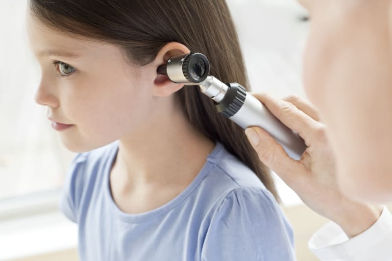 Doctor examining child's ear