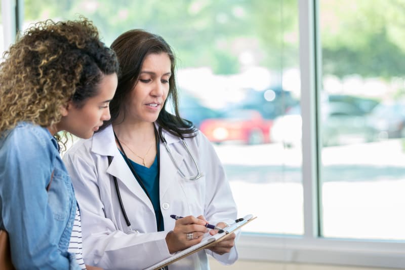 Doctor talking to female patient at clinic.