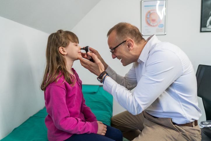 Doctor examining child's nose