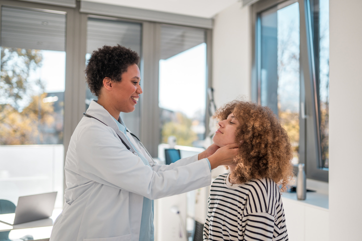 Doctor checking glands of teenage girl 