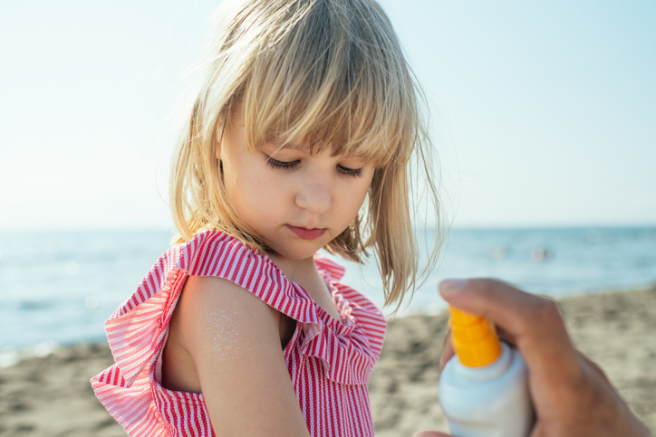 Parent putting sunscreen on child