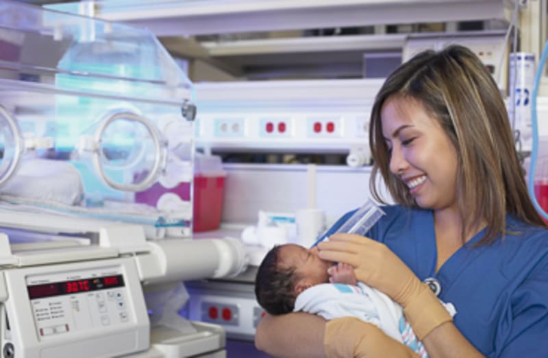 A nurse feeding a newborn in the Neonatal Intensive Care Unit.